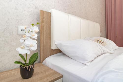 a bedroom with a white bed and a plant on a table at Salem in Zaozërnyy