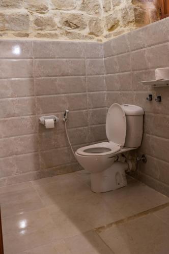 a bathroom with a toilet in a stone wall at Zad El Mosafer Guest House in Tunis