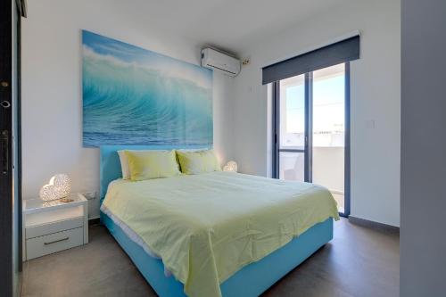 a bedroom with a bed with a painting on the wall at Perfect Location Idyllic 2BR Apartment in Sliema