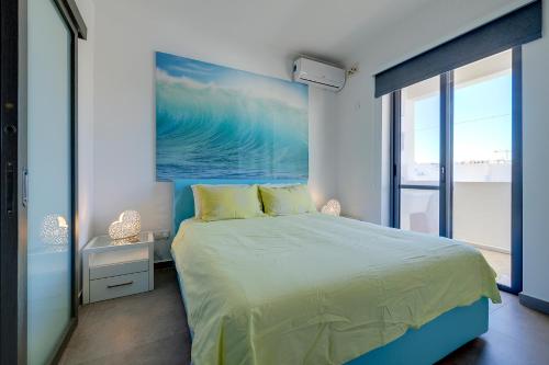 a bedroom with a bed and a painting of the ocean at Perfect Location Idyllic 2BR Apartment in Sliema