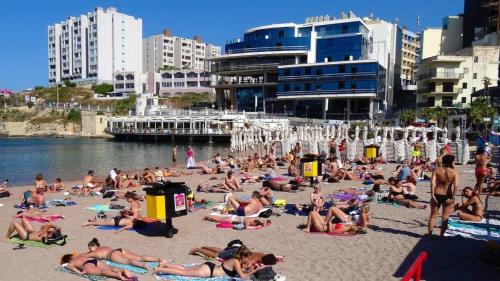 a large group of people on a beach at Perfect Location Idyllic 2BR Apartment in Sliema