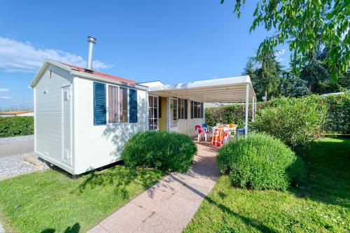 a small white tiny house in a yard at San Benedetto Camping Relais in Peschiera del Garda