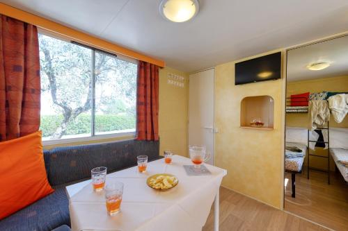 a room with a table and a room with a bed at San Benedetto Camping Relais in Peschiera del Garda