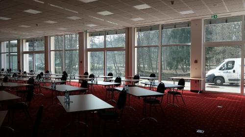 a room with tables and chairs and windows at Hotelpark der Westerwald Treff in Oberlahr