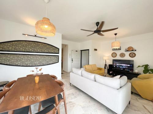 a living room with a white couch and a table at BayView Suites Port Dickson By MAISON in Port Dickson