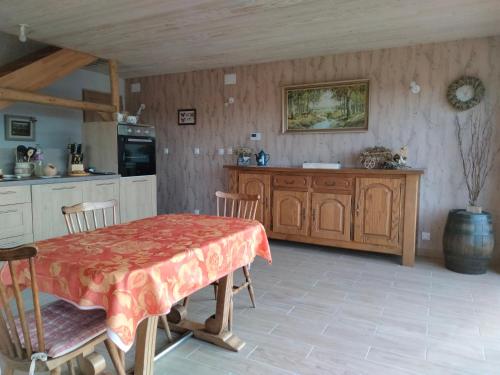 a kitchen with a wooden table and a table and chairs at Chez Nous in La Bresse