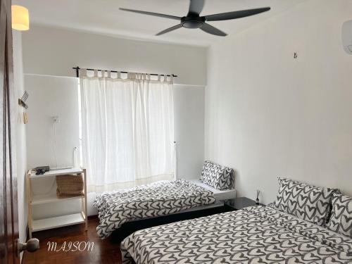 a bedroom with two beds and a ceiling fan at BayView Suites Port Dickson By MAISON in Port Dickson
