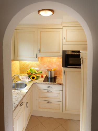 a kitchen with white cabinets and a sink at Boutique Appartments Gerlosperle in Gerlos