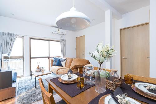 ein Wohnzimmer mit Tisch und Couch in der Unterkunft Mita Guest House by Tranova in Tokio