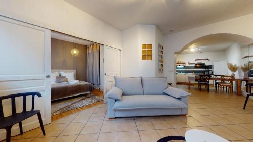 un salon avec un canapé bleu et une chambre dans l'établissement Magic Home - Les Taillandiers, à Colmar