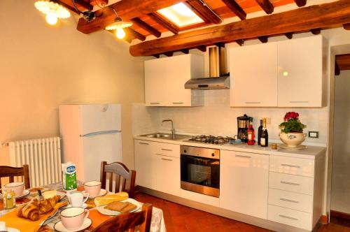 a kitchen with white cabinets and a table with food on it at Agriturismo La Marginella in Pescia