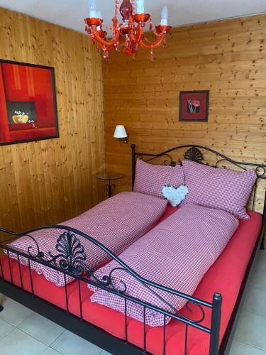 a bedroom with a bed with pink sheets and a chandelier at Ferienwohnung Allalinblick in Saas-Fee