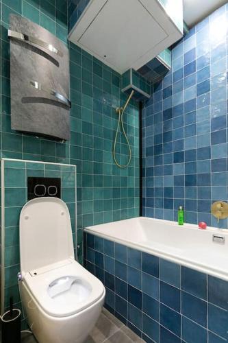 une salle de bain carrelée bleue avec toilettes et baignoire dans l'établissement Studio dans le 17ème, à 2km de Sacré Cœur, à Paris