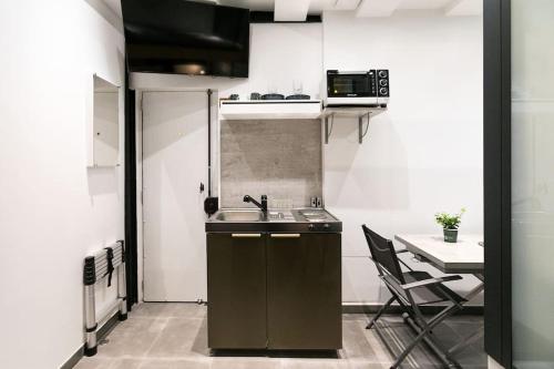 une petite cuisine avec un évier et une table dans l'établissement Studio dans le 17ème, à 2km de Sacré Cœur, à Paris