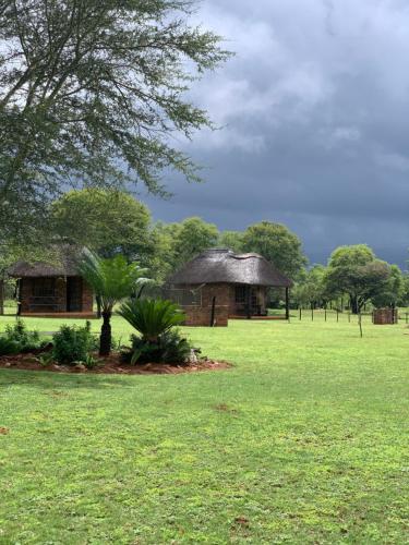 a house in the middle of a green field at Vilagama Game Lodge in Naboomspruit