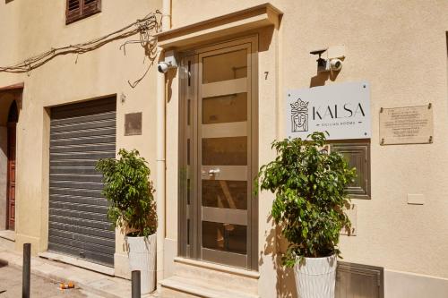 two potted plants on the side of a building at Kalsa Sicilian Rooms in Partinico
