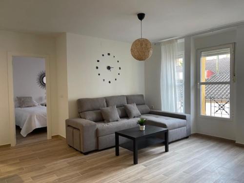 uma sala de estar com um sofá e uma mesa em Apartamentos Turísticos LOS BARRUECOS em Cáceres
