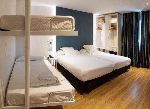 two bunk beds in a room with wooden floors at Bellavista Sevilla in Seville