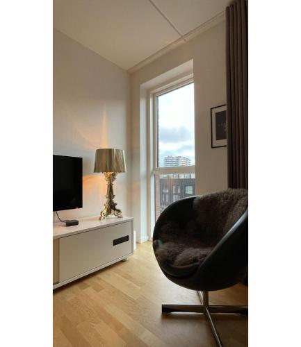 a living room with a chair and a television at ApartmentInCopenhagen Apartment 1518 in Copenhagen