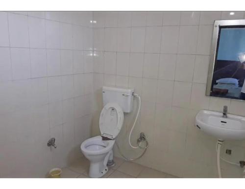 een badkamer met een toilet en een wastafel bij Hotel Royal Palace, Begusarai in Durjanpur