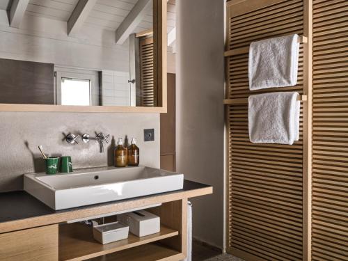 a bathroom with a white sink and a mirror at CERVO Mountain Resort in Zermatt