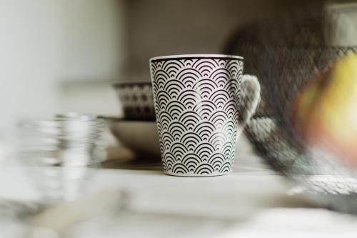 a white and black mug sitting on a counter at Wohnen auf Zeit in Weingarten in Weingarten