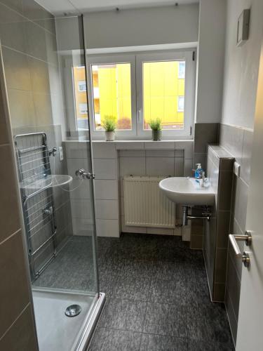 y baño con ducha y lavamanos. en Unique geräumige 4 Zimmer Wohnung in Tuttlingen mit Netflix, Sauna und Fitness, en Tuttlingen