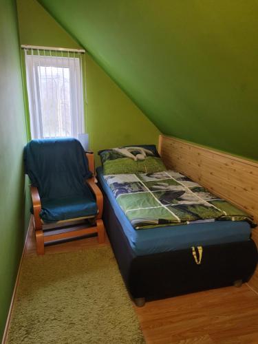 a bedroom with a bed and a chair and a window at Penzion U Elišky in Liberec