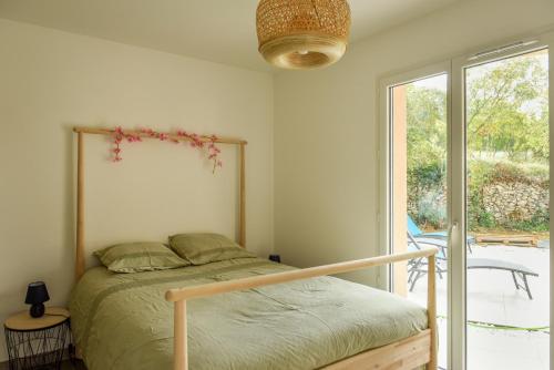 una camera da letto con un letto e una grande finestra di La Villa Adoé a Vallon-Pont-dʼArc
