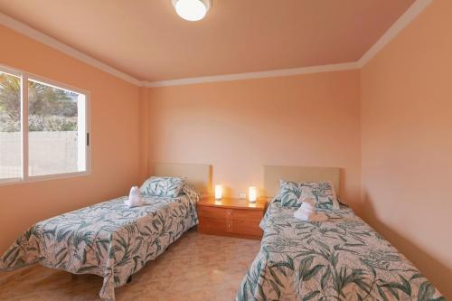 a bedroom with two beds and candles in it at clemente house,private pool in Arafo