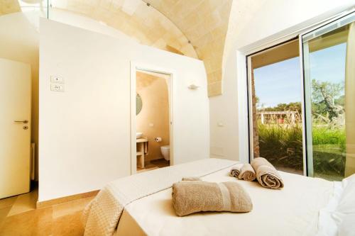 a bedroom with a bed and a large window at Luxury sea villa with pool near SM di Leuca in Castrignano del Capo