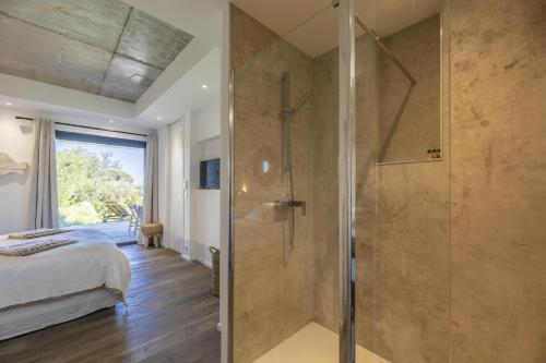 1 dormitorio principal con ducha y 1 cama en Appartement Stella en Sainte-Lucie de Porto-Vecchio