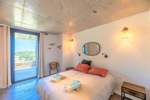 een slaapkamer met een groot bed en een groot raam bij Appartement Lea in Sainte-Lucie de Porto-Vecchio
