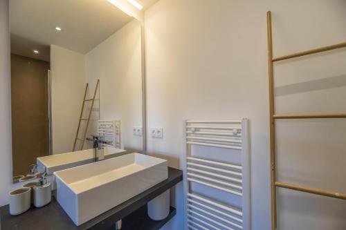 Appartement Lea في سانت لوسي دي بورتو فيشيو: حمام مع حوض أبيض ومرآة