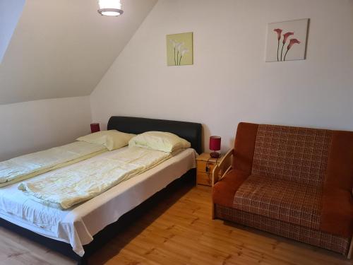 sypialnia z łóżkiem i krzesłem w obiekcie Mediterrán Apartman és Vendégház w Hajduszoboszlo