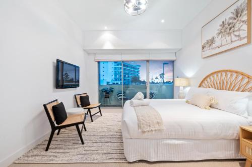 a bedroom with a large white bed and chairs at Suite 3201 Three Bedroom Luxe Oceanview Apartment in Mandurah
