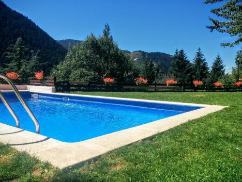 a swimming pool in the middle of a grass field at Estudio a pie de Pistas Baqueira in Baqueira-Beret