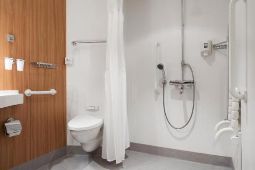 uma casa de banho com um chuveiro e um WC. em Tallink ferry - Baltic Queen Tallinn to Stockholm em Talin