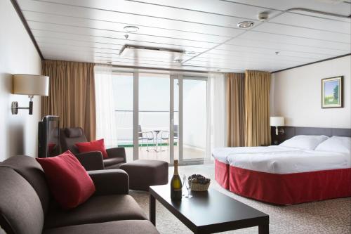 a hotel room with a bed and a couch at Tallink ferry - Baltic Queen Tallinn to Stockholm in Tallinn