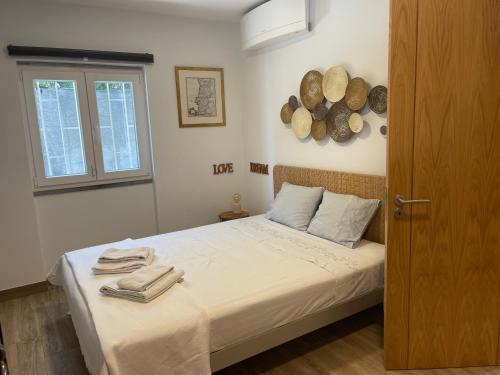 a bedroom with a bed with towels on it at Seaside Place Cascais in Carcavelos