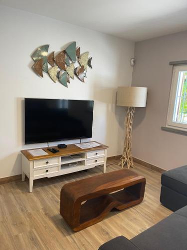 a living room with a flat screen tv and a coffee table at Seaside Place Cascais in Carcavelos