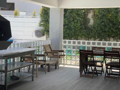 a patio with wooden tables and chairs and a balcony at Seaside Place Cascais in Carcavelos