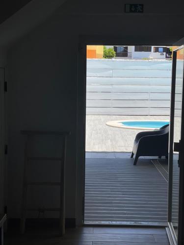 an open door to a patio with a table and a chair at Seaside Place Cascais in Carcavelos