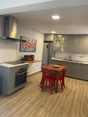 a kitchen with a table and red chairs in it at Seaside Place Cascais in Carcavelos