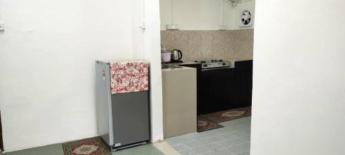 una pequeña cocina con nevera en una habitación en RZ Homestay en Kuala Terengganu