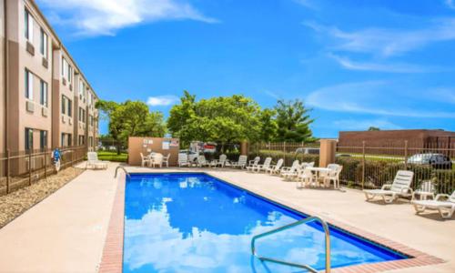 a swimming pool with patio furniture next to a building at Quality Inn Kansas City International Airport in Kansas City