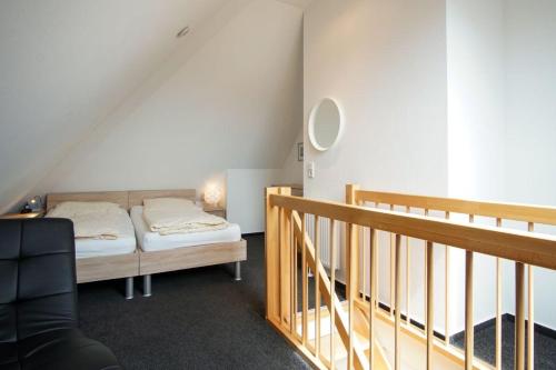 グローセンブローデにあるStrandpark-Grossenbrode-Haus-Wolkenlos-Wohnung-11-Cloud-Elevenのベッドルーム1室(ベッド1台付)、屋根裏部屋(階段付)