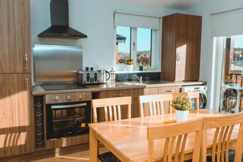 a kitchen with a wooden table and a dining room at Broadford Lodges Skye in Broadford