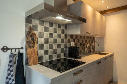 a kitchen with a sink and a stove top oven at Vakantiehuisje aan de rand van Arnhem in Arnhem