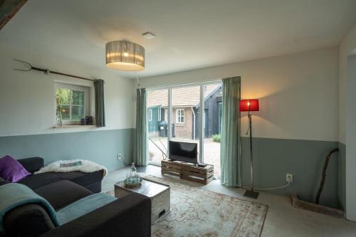 a living room with a couch and a tv at Vakantiehuisje aan de rand van Arnhem in Arnhem
